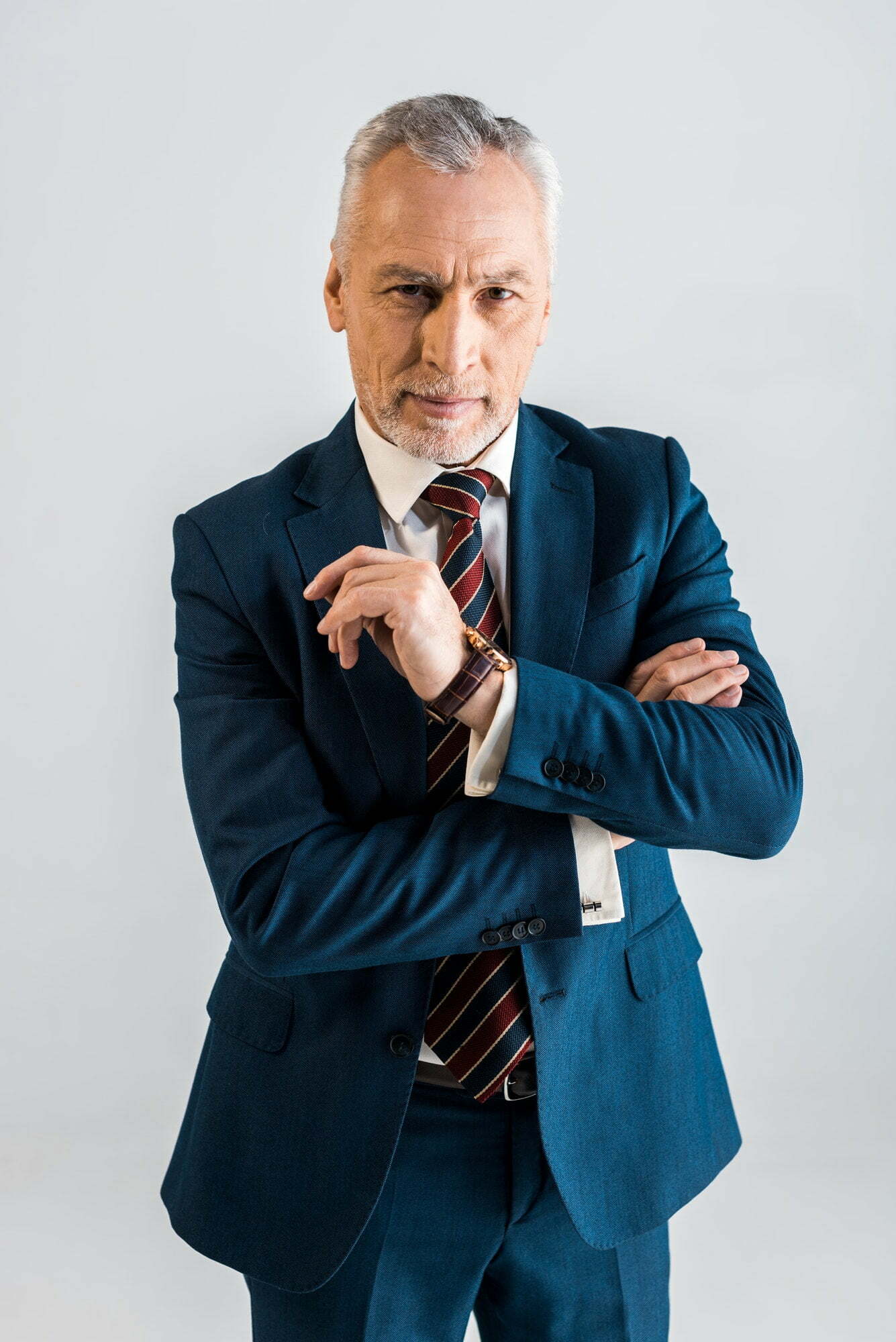 Fees 1 Pensive Mature Businessman In Suit Standing With Crossed Arms Isolated On Grey